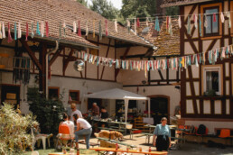 Ein Hof mit Fachwerkhäusern und bunten Fähnchen
