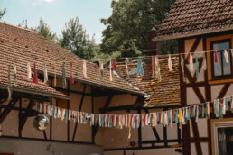 Ein Hof mit Fachwerkhäusern und bunten Fähnchen