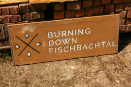 Ein Holzschild mit dem Logo des Festivals