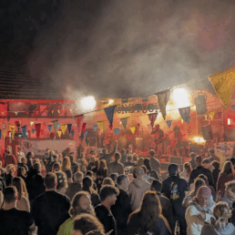 DIe Band Butterwegge vor einer Menschenmenge und bunten Fähnchen auf der Hofbühne