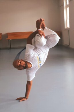 Camundongo macht die Bewegung &bdquo;Macaco&ldquo;, die genauso hei&szlig;t wie sein Meister. Er hat sie versucht, noch vor dem Grundschritt &bdquo;Ginga&ldquo;