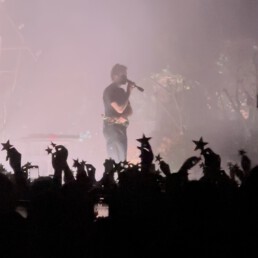 Edwin Rosen auf der Bühne, umringt von jubelnden Fans, die Sterne in den Händen halten.