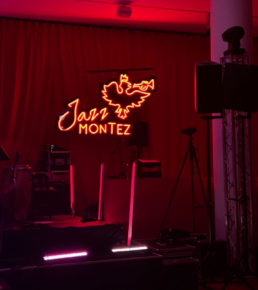Rot beleuchtete B&uuml;hne mit dem Schriftzug Jazz Montez im Hintergrund