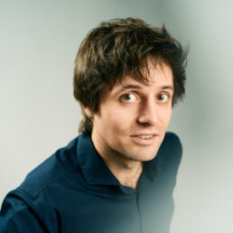 Lennart Schilgen schaut mit halb geöffnetem Mund in die Kamera über ihm.