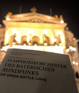Programmheft der Alten Oper mit angeleuchtetem Opernhaus im Hintergrund