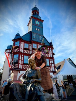 Die lebendige Tabakn&auml;herin neben ihrem Vorbild auf dem Brunnen, Lorscher Kerb 2025