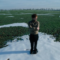 Ein Mann steht auf einem Feld mit Schneehaufen